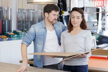 Obraz premium serious couple making decision on wood finish