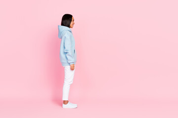 Fototapeta na wymiar Profile side full length photo of cheerful adorable lady wear blue comfort clothes look empty space isolated on pink color background