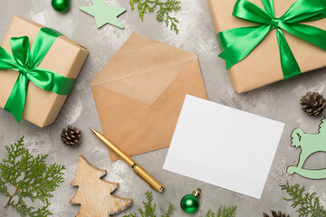 Craft envelope with christmas decoration on concrete background, top view