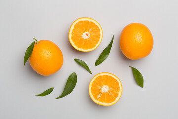 Flat lay with fresh oranges and leaves on color background
