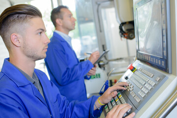 Young technician using computer in factory