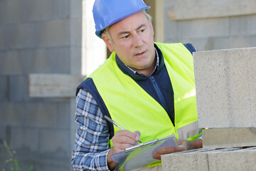 man builder records something on clipboard