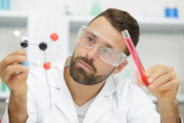 scientist checking filled test tubes with pipette in lab