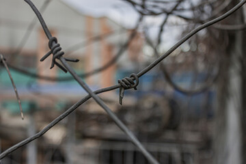 Crossed barbed wire with warehouse on background