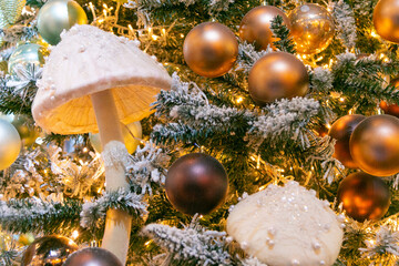 Magic pink and porcini mushrooms and a lot of Christmas balls on the Christmas tree.  New Year mood. Festive Christmas toys. Close-up.