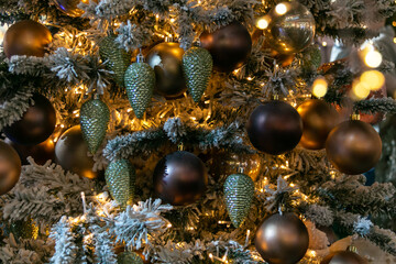 Obraz na płótnie Canvas Lots of golden Christmas balls and Christmas cones on the Christmas tree. Festive Christmas toys. Christmas decorations. Close-up..