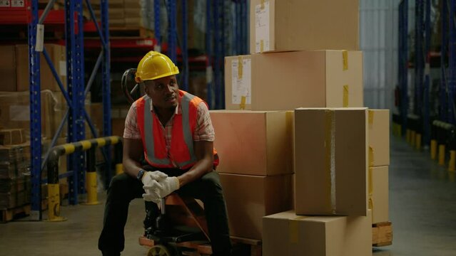 African american worker sitting isolated inside a warehouse,warehousing, distribution, transport
