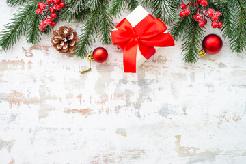 Christmas holiday decorations at white background with copy space. Gift boxes, fir tree, baubles and others. Flat lay composition.