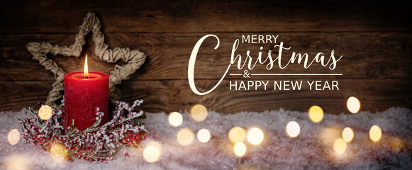 Christmas Greeting Card with English text Merry Christmas and Happy New Year. Panorama, Banner. Christmas candle in winter snow landscape with magic lights. Xmas Wood background with copy space.
