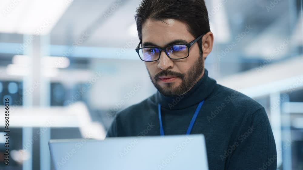 Poster portrait of a professional hispanic man using laptop at work in research and development agency. you