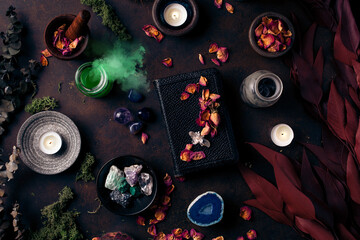 Witchcraft still life concept with smoking potion, spell book, herbs ingredients candles and...