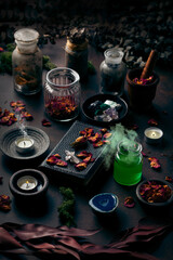 Witchcraft still life concept with smoking potion, spell book, herbs ingredients candles and magical equipment