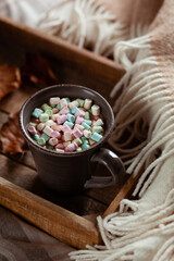 warm cozy bedroom winter or autumn concept, cup of hot chocolate on tray, throw
