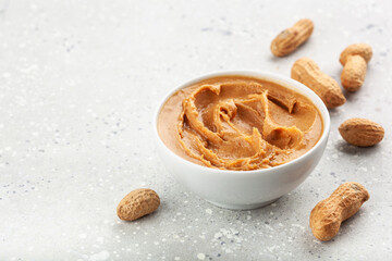 smooth peanut butter in bowl on gray background