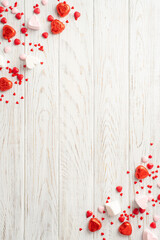 Valentine's Day mood concept. Top view vertical photo of heart shaped candies on white wooden desk background with copyspace