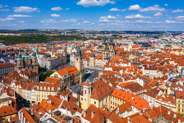 Fototapeta na wymiar Prague beautiful panoramic sunny aerial drone view above Prague Old Town Square with Church of Our Lady before Tyn and Prague Astronomical Clock Tower. Drone flight over red roofs of Prague, Czechia.