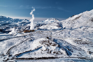 Aerial view to geothermal power plant in mountain. Clean green renewable energy in Kamchatka. - 550658617