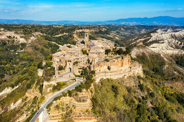 The famous Civita di Bagnoregio on a sunny day. Province of Viterbo, Lazio, Italy. Medieval town on the mountain, Civita di Bagnoregio, popular touristic stop at Tuscany, Italy. - obrazy, fototapety, plakaty