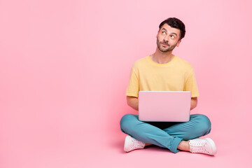 Photo of minded man wear stylish clothes look empty space dream new device apple macbook isolated on pink color background