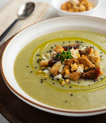 Vegetable cream with zucchini and potato. Typical Spanish tapa recipe decorated with croutons, hard-boiled egg and black sesame.