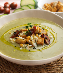 Vegetable cream with zucchini and potato. Typical Spanish tapa recipe decorated with croutons, hard-boiled egg and black sesame.