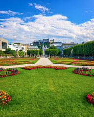 Obraz premium Beautiful view of famous Mirabell Gardens with the old historic Fortress Hohensalzburg in the background in Salzburg, Austria. Famous Mirabell Gardens with historic Fortress in Salzburg, Austria.
