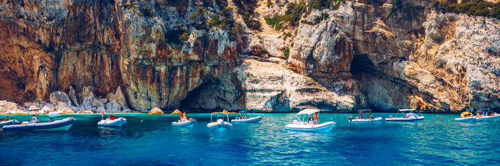 Blue sea and the characteristic caves of Cala Luna, a beach in the Golfo di Orosei, Sardinia, Italy. Big sea caves in the mediterranean coast. Sardinia, Italy.