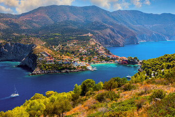 Obraz premium Assos village in Kefalonia, Greece. Turquoise colored bay in Mediterranean sea with beautiful colorful houses in Assos village in Kefalonia, Greece, Ionian island, Cephalonia, Assos village.