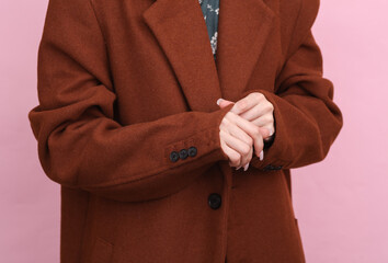 Fashion woman in dress and woolen coat posing on pink background