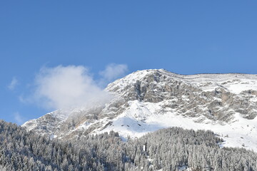 Mountain peak under the snow viewed from below in Austrian Alps on a sunny, winter day