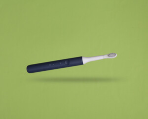 Ultrasonic toothbrush levitating on a green background