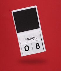 Wooden calendar with March 08 date levitating on red background. World Women's Day