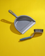 Scoop for cleaning with brush on a yellow background. Creative layout