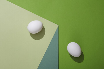 Eggs on a paper cube. Optical illusion. Geometric composition. Minimalistic creative layout