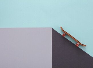 Toy skateboard on a paper cube. Optical illusion. Geometric composition. Minimalistic creative layout