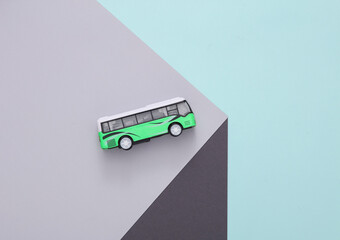 Toy bus on a paper cube. Optical illusion. Geometric composition. Minimalistic creative layout