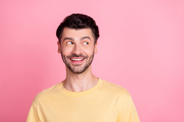 Photo of handsome good mood positive guy with brunet hair dressed yellow t-shirt look empty space isolated on pink color background