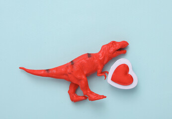 Toy tyrannosaurus with hearts on a blue background. Love concept