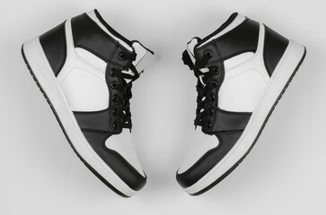Black and white sneakers on a white background, top view. Stylish new sneakers for advertising a shoe store