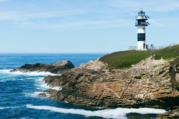 Fototapeta na wymiar small white and blue lighthouse in town of Galicia, Spain