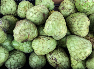 Organic cherimoya fruit displayed at a farm market stall in southern California