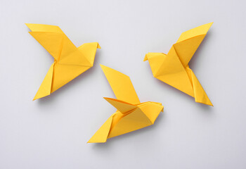 Yellow origami doves on a gray background. Peace symbol, no war