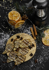 christmas decoration of dried pears in chocolate on a wooden stand of cinnamon oranges and Christmas tree branches of a lantern on a dark background. for postcards menu labels calendars signs and stan