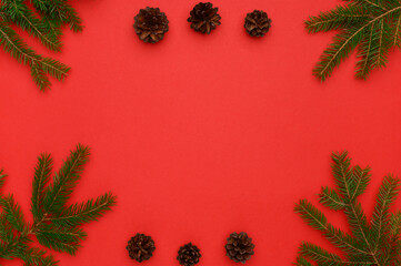 Christmas, winter composition.Frame of fir branches and cones on a red background.Concept of Christmas,new year.Flat lay