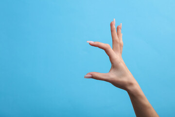 Female hand mockup holding empty space for holding business card on blue background