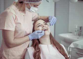 Obraz na płótnie Canvas Professional dentist examines a patient's teeth in a dental clinic. Dental care concept