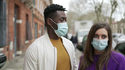 Fototapeta na wymiar People wearing covid-19 face mask standing outside in street
