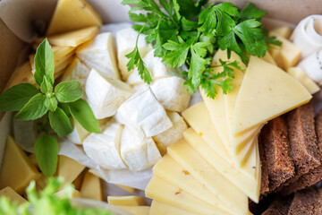 cheese platter and a lot of different types of cheeses. Delicious snacks close-up. Delivery box.