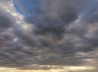 Obraz premium Fondo natural con multitud de nubes en tonos azules y grises, con rayo de sol filtrados
