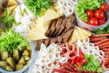 Meat, sausage products, an assortment of cheeses, pickled vegetables and lettuce in box for delivery
